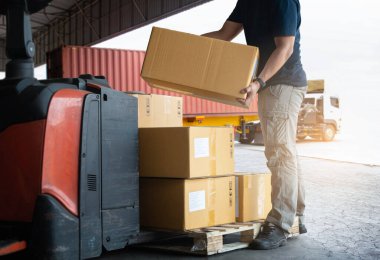 Depo çalışanları, Palet 'e paket kutusu yüklüyorlar. Kutular, karton kutular. Tedarik zinciri, Sevkiyat Kutuları, Malzeme Deposu Nakliyat. Lojistik Deposu.