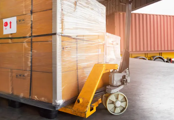 Package Boxes on Pallets and Hand Pallet truck. Loading into Container Trucks. Distribution Supplies Warehouse Shipping. Supply Chain, Shipment. Freight Truck Logistics Transport.