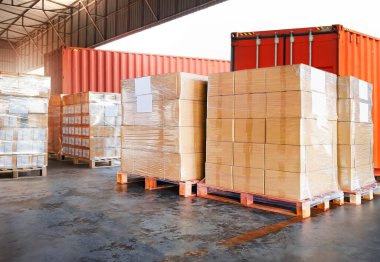 Paket Kutuları Paletlere Paketlenmiş Plastik. Depo rıhtımında kamyonlar yükleniyor. Dağıtım Deposu Nakliyat, Tedarik Zinciri Malzemeleri, Sevkiyat. Nakliye Aracı Lojistik Taşımacılığı.