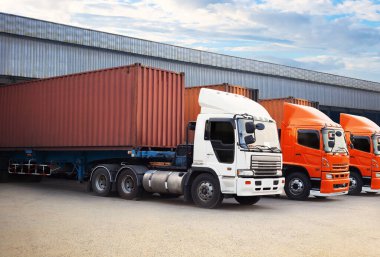 Deponun otoparkındaki yarı karavan kamyonları. Malları Depo 'ya yükleyen kamyonlar. Konteynır nakliyesi. Nakliye Aracı Lojistik Kargo Taşımacılığı.