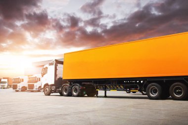  Sunset ile birlikte Depo 'daki otoparkta yarı karavan kamyonları. Dağıtım Deposu Merkezi. Kargo konteynırı nakliyesi. Nakliye Aracı Lojistik Taşımacılığı.