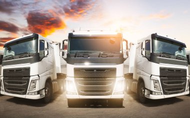 Sunset Sky ile park alanında yarı karavan kamyonları. Kargo konteynırı nakliyesi. Ekonomik İş Taşımacılığı Yolda. İçeri- Dışarıya aktar. Kamyonculuk. Lorry Diesel Truck. Yük Lojistik Taşımacılığı.