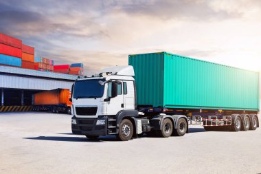 Depo Limanı 'ndaki otoparkta yarı karavan kamyonları. Rıhtım deposunda yük kamyonu var. Dağıtım Deposu Merkezi. Konteynır nakliyesi. Nakliye Aracı Lojistiği, Kargo Taşımacılığı.