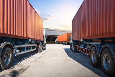 Deponun otoparkındaki yarı karavan kamyonları. Rıhtım deposunda yük kamyonu var. Dağıtım Deposu Merkezi. Nakliye konteynerleri. Nakliye Aracı Lojistiği, Kargo Taşımacılığı.