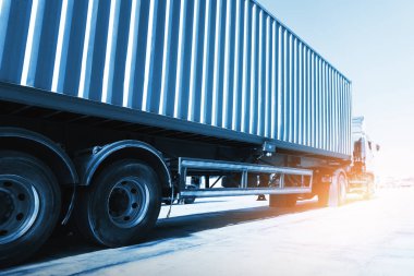 Park alanında Sunshine 'lı yarı karavan kamyonları. Traktör kamyonu. Büyük kamyon. Ekonomik İş Taşımacılığı Yolda. Nakliye Konteynırı İthalatı - İhraç. Kamyonculuk. Nakliye Aracı Lojistik Taşımacılığı