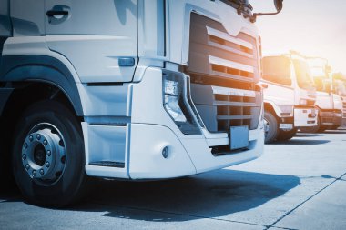 Depo 'daki otoparkta yarı kamyonlar. Traktör kamyonu, kargo konteynırı. Malları Depo 'ya yükleyen kamyonlar. Dağıtım Deposu. Büyük kamyon. Nakliye Aracı Taşımacılığı.