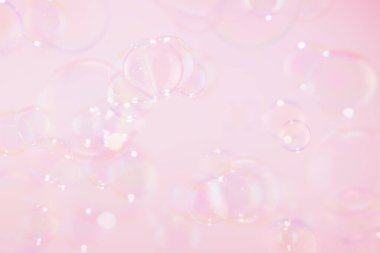 Güzel şeffaf pembe sabun köpükleri havada süzülüyor. Kutlama Şenliği Arkaplanı. Tazelik sabunu köpüklü su. Pembe ve Beyaz Dereceli.