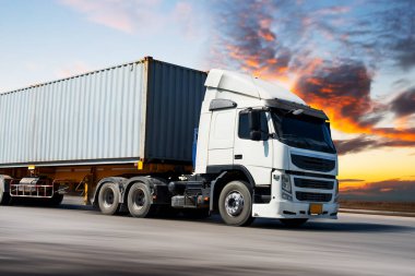 Yarı Karavan Kamyonları Sunset Sky 'da Yolda Sürüyor. Kargo konteynırı. Ekonomik İş Taşımacılığı Yolda. Nakliye İthalat-İhracat. Kamyonculuk. Nakliye Aracı Taşımacılığı.