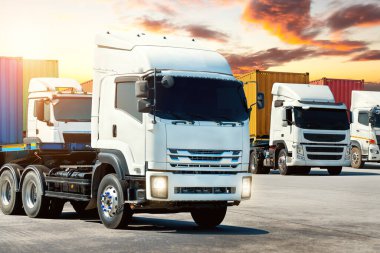 Sunset Sky 'daki otoparkta yarı karavan kamyonları. Büyük Rig. Traktör kamyonu. Limanda kargo kamyonu nakliyesi. Ekonomik İş Taşımacılığı Yolda. Kamyonculuk. Yük Lojistik Taşımacılığı.