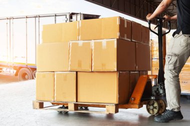 İşçiler paket kutularını kamyona yüklüyorlar. Forklift Palet Jack. Paket kutuları. Nakliye konteynırı. Dağıtım Deposu, Malzeme Zinciri, Sevkiyat, Nakliye Kamyonu Lojistik Taşımacılık.