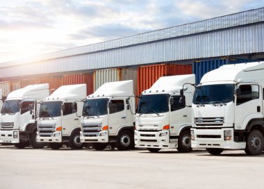 Depo 'daki otoparktaki yarı karavan kamyonları. Kargo konteynırı. Rıhtım deposunda yük kamyonu var. Dağıtım Deposu. Büyük kamyon. Nakliye Aracı Taşımacılığı