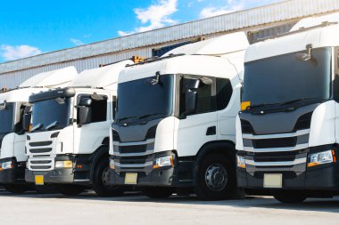 Depo 'daki otoparkta yarı karavan kamyonları. Kargo konteynırı. Rıhtım deposunda yük kamyonu var. Dağıtım Deposu. Büyük kamyon. Nakliye Aracı Taşımacılığı