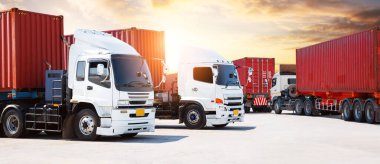 Sunset Sky 'daki otoparkta yarı karavan kamyonları. Büyük Rig. Traktör kamyonu. Limanda kargo kamyonu nakliyesi. Ekonomik İş Taşımacılığı Yolda. Kamyonculuk. Yük Lojistik Taşımacılığı.