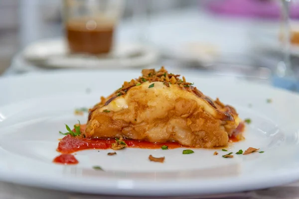 Domates soslu, beyaz bir tabakta haşlanmış hake.