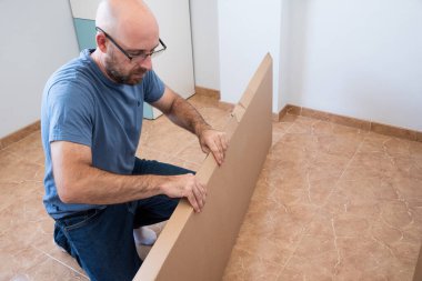 Mobilya montajı yapan bir adamın portresi. Mobilya takımını kendin yap..