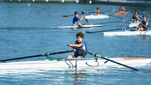 Boy training rowing on a lake near his home with his companions, the focus and background out of focus while rowing.