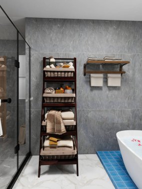 Gri mermer duvarlı modern banyo çiçek yapraklarıyla süslenmiş beyaz küvet mavi fayanslı basamak katlanmış havlularla ahşap askılar ve cam duş kapısı. Doğal dokuları olan minimalist bir tarz..