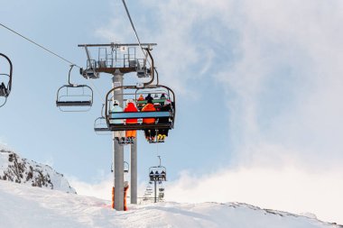 Up to the Slopes: Unrecognizable Skiers on a Chairlift