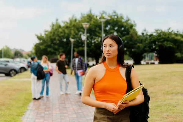 Μια Ασιάτισσα Φοιτήτρια Περπατά Προσεκτικά Ακούγοντας Μουσική Στα Περίχωρα Της — Φωτογραφία Αρχείου