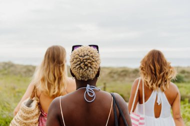 Üç farklı ırktan kadın arkadaş grubu bir yaz günü sahile birlikte yürür. Yaz tatili ve boş zaman kavramı.