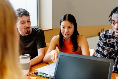 Çok ırklı bir grup, Asyalı genç bir kıza odaklanmış, birlikte çalışıyor ve okul konusunu tartışıyorlar. Üniversitede hayat. Sınıf arkadaşları.