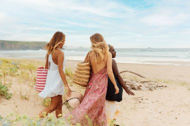 Bir yaz günü, bir gezi sırasında plajda birlikte yürüyen üç genç kadının olduğu çok ırklı bir grup. Arkadaşlarınla seyahat et.