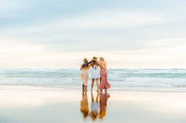 Farklı ırktan üç genç kadının oluşturduğu çok ırklı bir grup sahili gezerek denize bakıyorlar. Arkadaşlık ve birlik. Yaz gezisi.