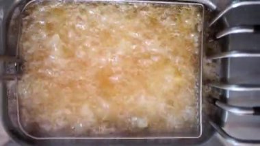 Kızgın yağla çalışan endüstriyel fritöz. Sağlıksız yemek, kızarmış yemek, yağ ve kalori..