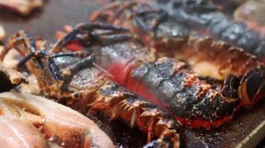 Lokanta mutfağında ıstakoz ve ahtapot ızgara yapıyor.