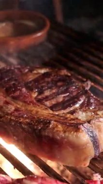 Lokanta mutfağında profesyonel bir aşçı tarafından tuzla tatlandırılmış alevler içinde ızgara pirzola.