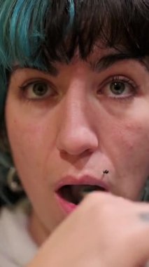 Dişlerini diş fırçasıyla fırçalayan kadın, farklı ifadeler sergiliyor.