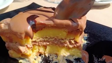 Kremalı ve çikolatalı tatlının tadını bir kaşıkla çıkarıyoruz. Kremalı ve katmanlı dokusunu ortaya çıkarıyor.