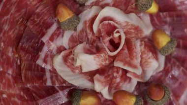 Premium iberian palamudu jambon dilimleriyle beslenmiş narin çiçek desenleri oluşturarak, geleneksel İspanyol mutfak sanatını vurgulayan dağınık meşe palamudu ile zarif bir şekilde dönüyor.