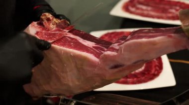 Profesyonel şef İber palamudunu ustalıkla dilimliyor jambonla besleniyor, hassas mermer ve kaliteli et dokusunu gözler önüne seriyor.