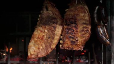 Restoranın mutfağında mangalda ızgara yapan domuz kaburgaları pişirme sürecini gösteriyor.
