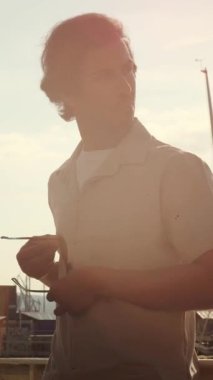 Başarılı Hintli yönetici şık güneş gözlüğü takıyor, kollarını kavuşturarak limanda duruyor, profesyonel başarıyı ve şehir yaşam tarzını somutlaştırıyor.