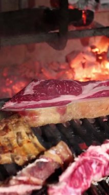 Cızırdayan ızgara pirzola, ananas ve yedek pirzola parlayan közler üzerinde karamelize oluyor, zengin kömürleşmiş tatlarla ağız sulandıran barbekü deneyimi yaratıyor.