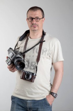 Boynunda çeşitli kameralar olan fotoğrafçı.