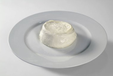 Beyaz arka planda yumuşak peynirli tabak.