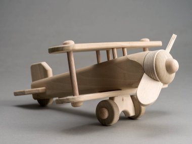 Gri bir arka planda, ahşap model bir uçağın hayatı