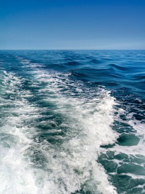 Teknenin motorları tarafından hareket ettirilen suyla deniz manzarası.