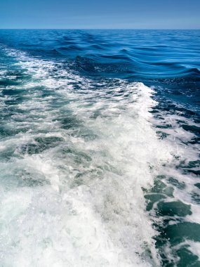 Teknenin motorları tarafından hareket ettirilen suyla deniz manzarası.