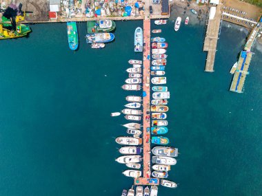 Çeşitli teknelerle dolu hareketli bir limanın Boğaz Yüksek açılı görüntüsü. Rıhtım boyunca demirlemiş sayısız farklı boyda ve renkte teknelerin bulunduğu bir marinanın havadan çekilmiş görüntüsü. Beykoz Poyrazkoy İstanbul