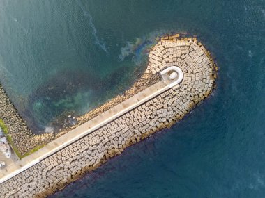 Bir Kıyı Dalgakıran Yapısı 'nın havadan görünüşü. Yüksek açı, dalgakıranın tam görüntüsü, birbirine kenetlenmiş beton bloklardan inşa edilmiş, deniz mavisi bir alana kadar uzanıyor. Beykoz Poyrazkoy İstanbul Türkiye