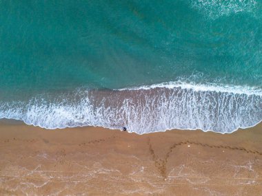 Karasu Tranquil Beach Scene with Foamy Waves and Footprints. High-angle, aerial view of a serene beach scene. Sakarya Adapazari Turkiye Drone Shot nice summer advertisement and nature background  clipart