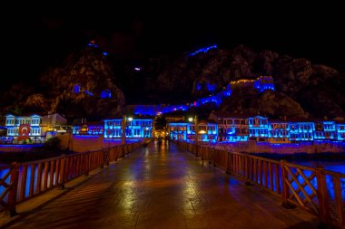 Amasya, Turkey - August, 2017: Old Ottoman houses and Clock Tower with night and mirrored view by the Yesilirmak River in Amasya, Turkey clipart