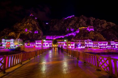 Amasya, Türkiye - Ağustos 2017: Türkiye 'nin Amasya kentindeki Yesilirmak Nehri' nin gece ve aynalı manzaralı eski Osmanlı evleri ve Saat Kulesi