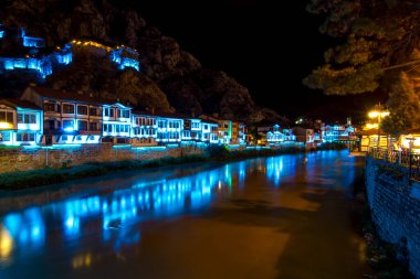 Amasya, Turkey - August, 2017: Old Ottoman houses and Clock Tower with night and mirrored view by the Yesilirmak River in Amasya, Turkey clipart