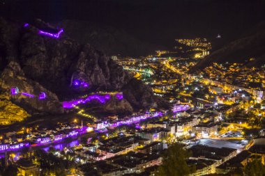 Amasya, Türkiye - Ağustos 2017: Türkiye 'nin Amasya kentindeki Yesilirmak Nehri' nin gece ve aynalı manzaralı eski Osmanlı evleri ve Saat Kulesi