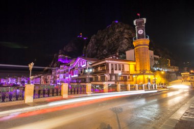 Amasya, Türkiye - Ağustos 2017: Türkiye 'nin Amasya kentindeki Yesilirmak Nehri' nin gece ve aynalı manzaralı eski Osmanlı evleri ve Saat Kulesi